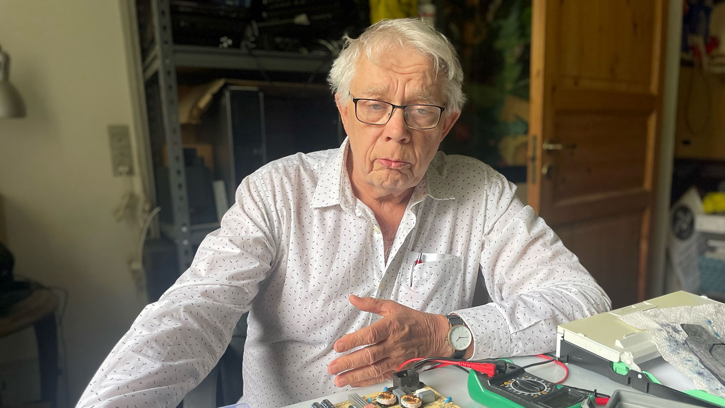 Mand, der sidder ved et bord.