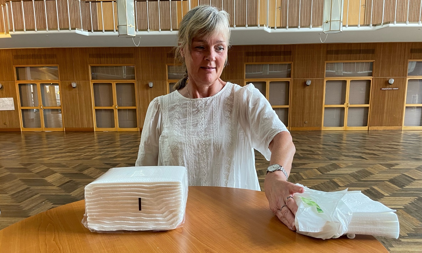 En kvinde siddende med et bord med engangsskumklude foran sig